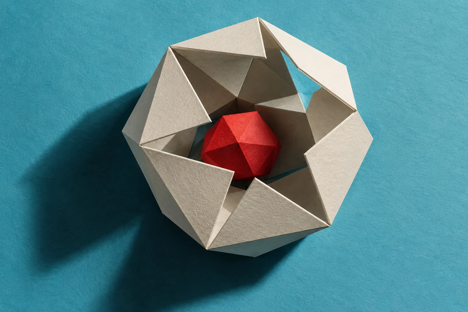 Escultura de papel con una carcasa abierta y un núcleo rojo; metáfora IA sin interfaz real.