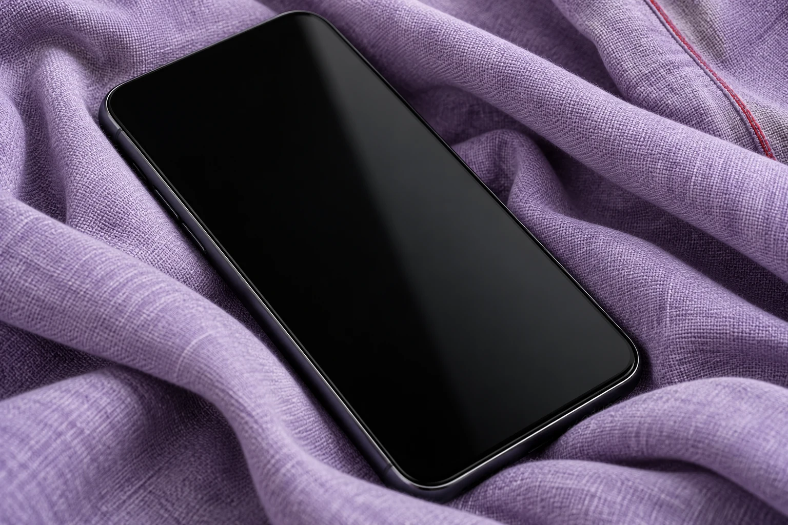Teléfono sin marca ni pantalla encendida sobre tela; ilustración IA, no un iPhone probado ni una medición de almacenamiento.